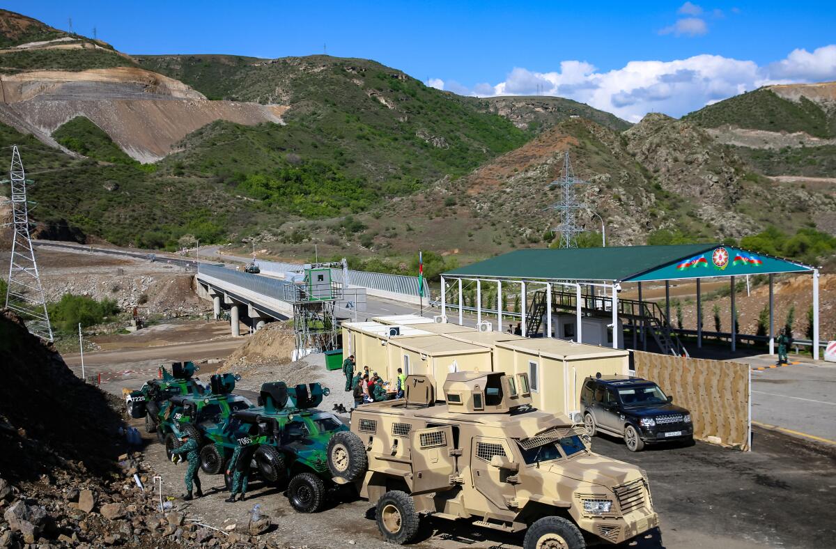 Azerbaijani military vehicles and personnel at a highway checkpoint at the entry of the Lachin corridor