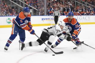 Los Angeles Kings' Viktor Arvidsson (33) competes for the puck against Edmonton Oilers' Cody Ceci (5) and Darnell Nurse (25) during the third period of Game 5 of an NHL hockey Stanley Cup first-round playoff series Tuesday, April 25, 2023, in Edmonton, Alberta. (Jason Franson/The Canadian Press via AP)