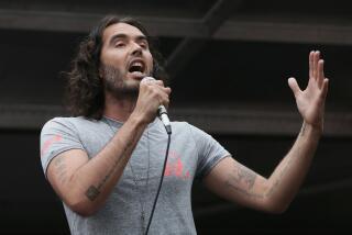 Comedian Russell Brand speaks in Parliament Square during a protest against the Conservative Government and it's austerity policies in London, Saturday, June 20, 2015. The protest is intended to be peaceful, but demonstrators are angry at public sector cuts meant to address government deficits, which ballooned after Britain rescued troubled banks during the 2008 financial crisis. Demonstrators argue the public is being punished for a crisis it did not cause. (AP Photo/Tim Ireland)