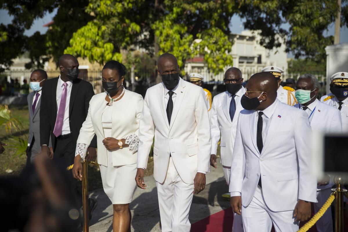 FILE - In this May 18, 2021 file photo, Haitian President Jovenel Moise, center, walks with first lady Martine Moise, left, and interim Prime Minister Claude Joseph, right, during a ceremony marking the 218th anniversary of the creation of the Haitian flag in Port-au-Prince, Haiti. Moïse was assassinated in an attack on his private residence early Wednesday, and the first lady was shot in the overnight attack and hospitalized, according to a statement from Joseph. (AP Photo/Joseph Odelyn, File)