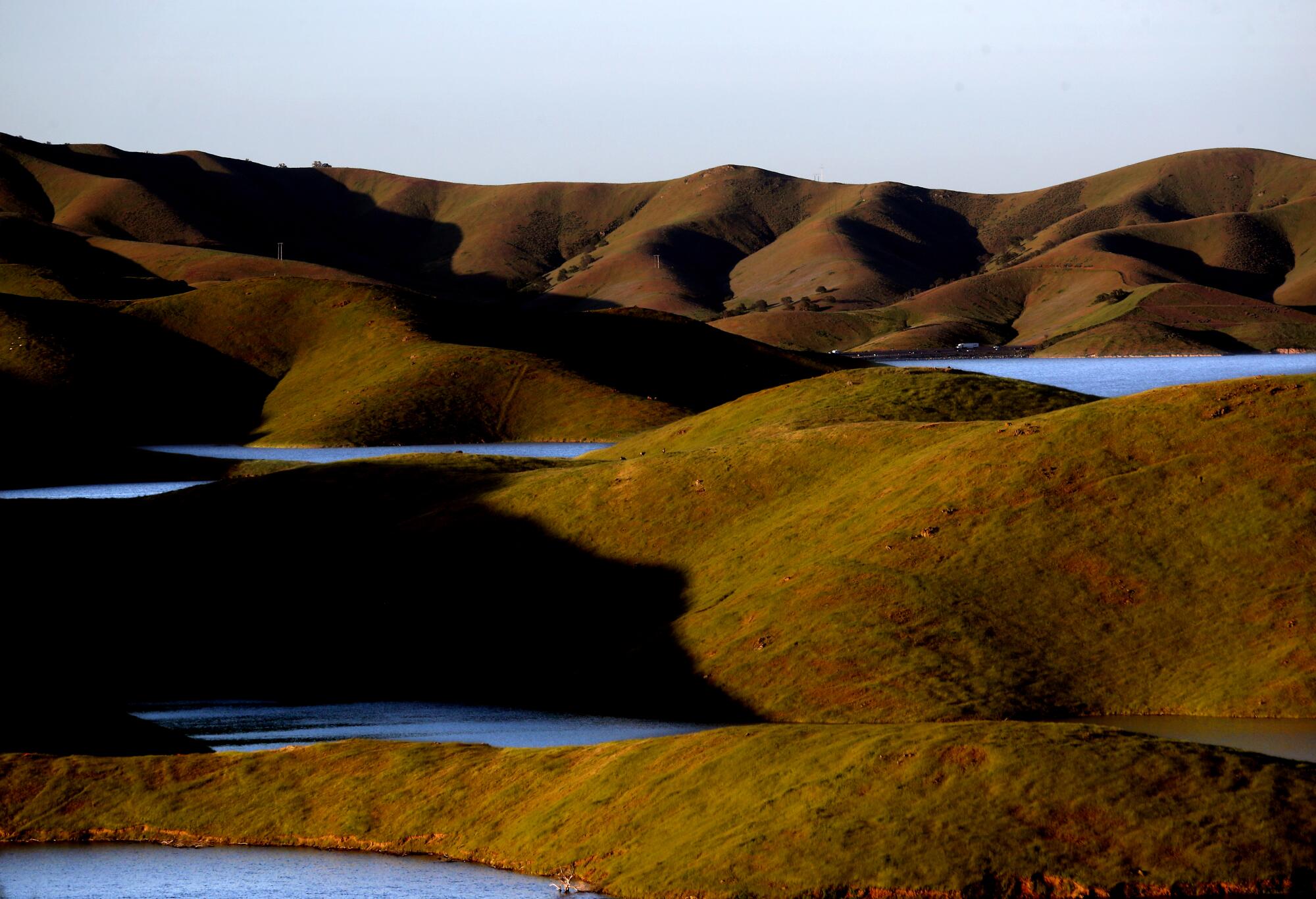 A view of bodies of water amid rolling brown hills 