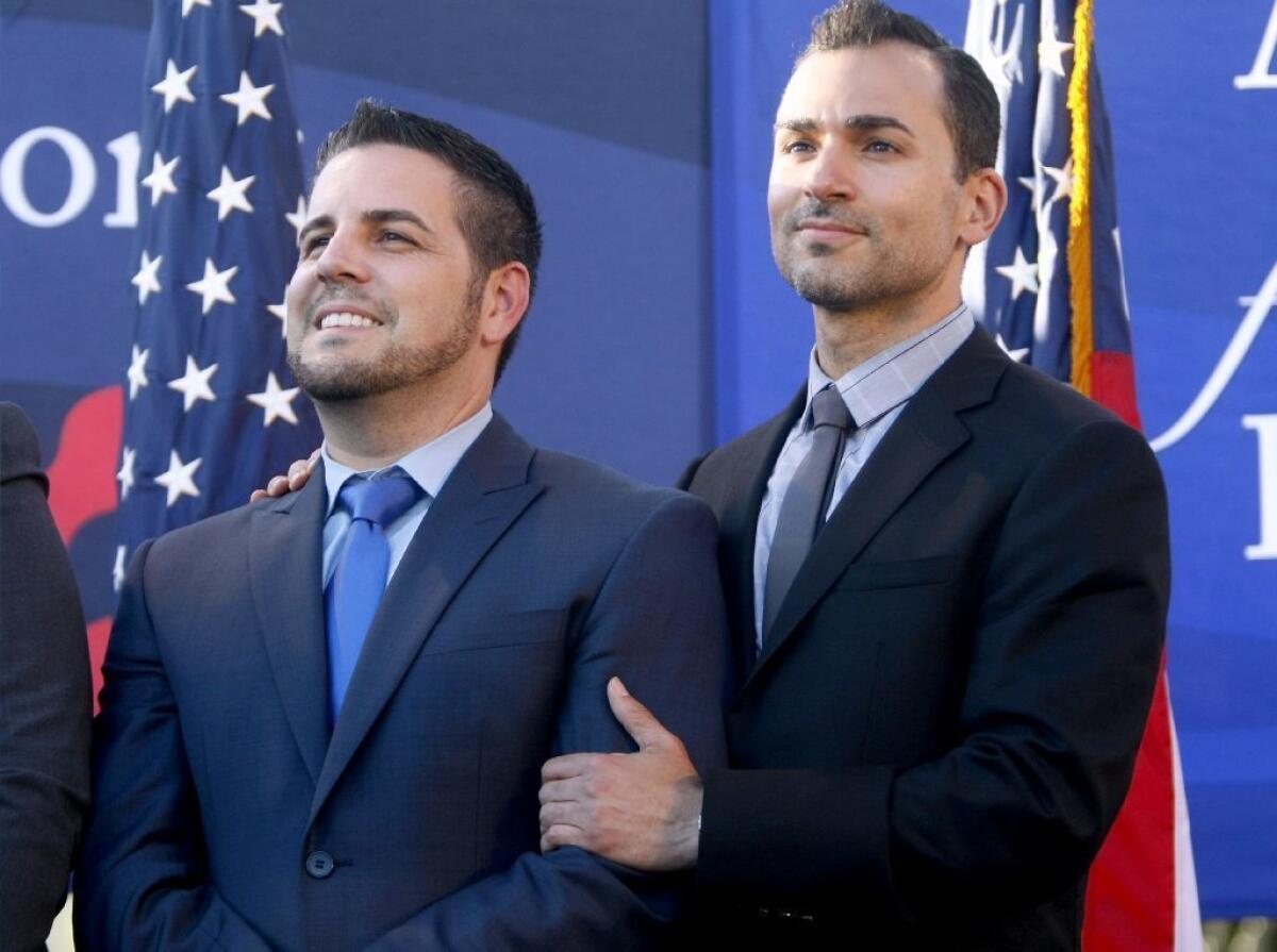 Paul Katami of Burbank, right and his partner Jeff Zarillo, left celebrate after the Supreme Court struck down a key part of the federal Defense of Marriage Act, during a rally in West Hollywood, on Wednesday, June 26, 2013.