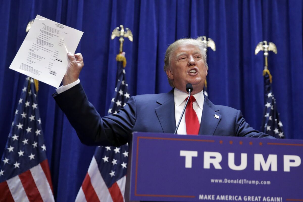 Donald Trump displays a document reportedly showing his net worth.