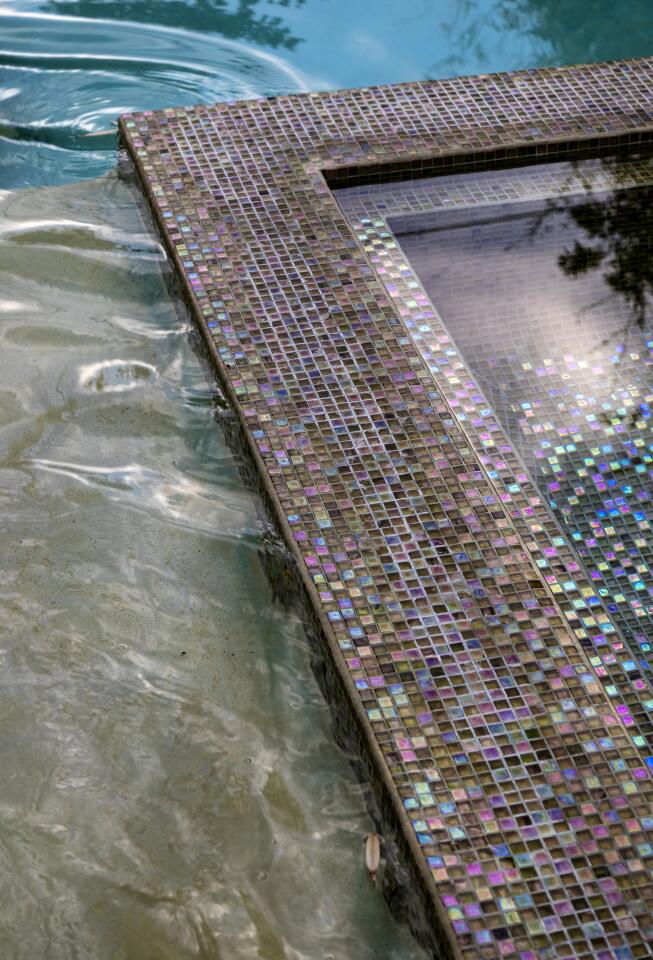 A glass-tiled spa was created in the pool, replacing an outdated hot tub and bringing the design into the 21st century.