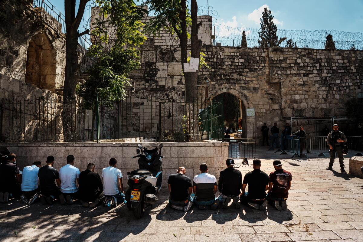 Men kneel on tiles for Friday prayers.