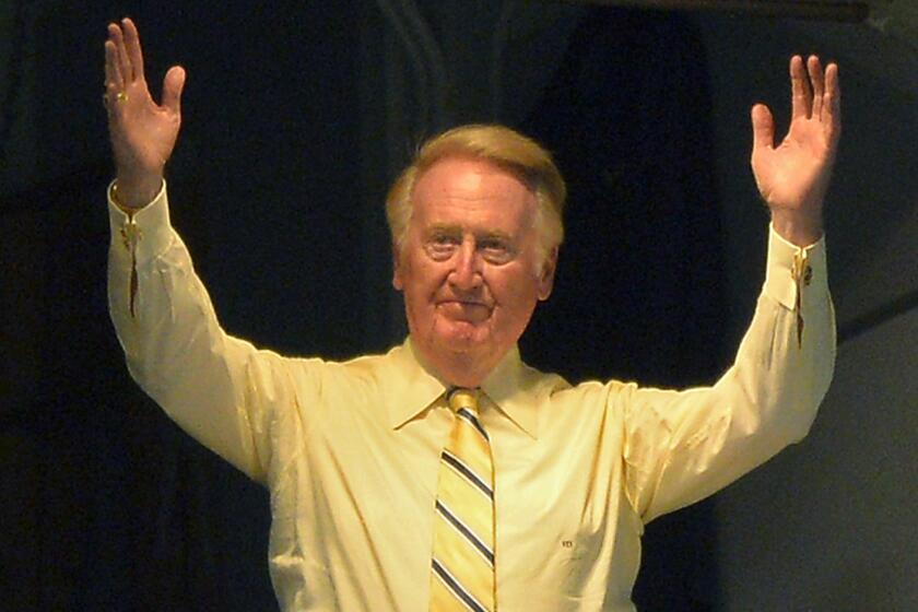 Vin Scully acknowledges the cheers of the crowd during his bobblehead night at Dodger Stadium on July 25, 2013.