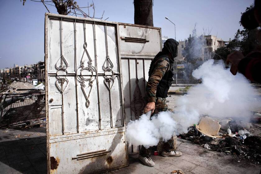 A fighter with the Free Syrian Army throws a homemade smoke bomb to blind government soldiers in Aleppo. With informants a major concern to both sides in the conflict, FSA leaders have created their own intelligence branch to weed out spies and to recruit them.