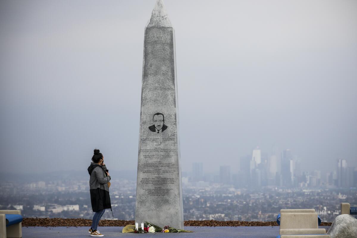 A woman reads the inscription on the Martin Luther King Jr. Memorial in Kenneth Hahn State Recreational Area