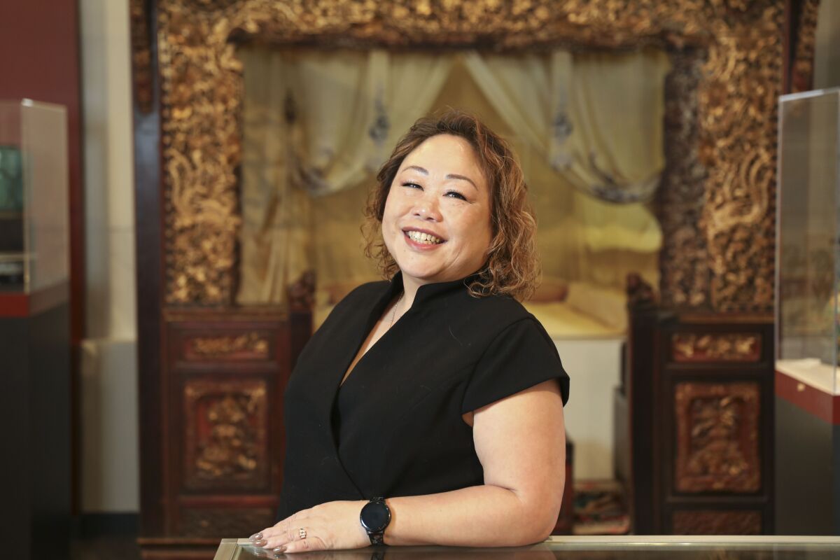 Jacinta Wong stands in the gallery space at the San Diego Chinese Historical Museum.