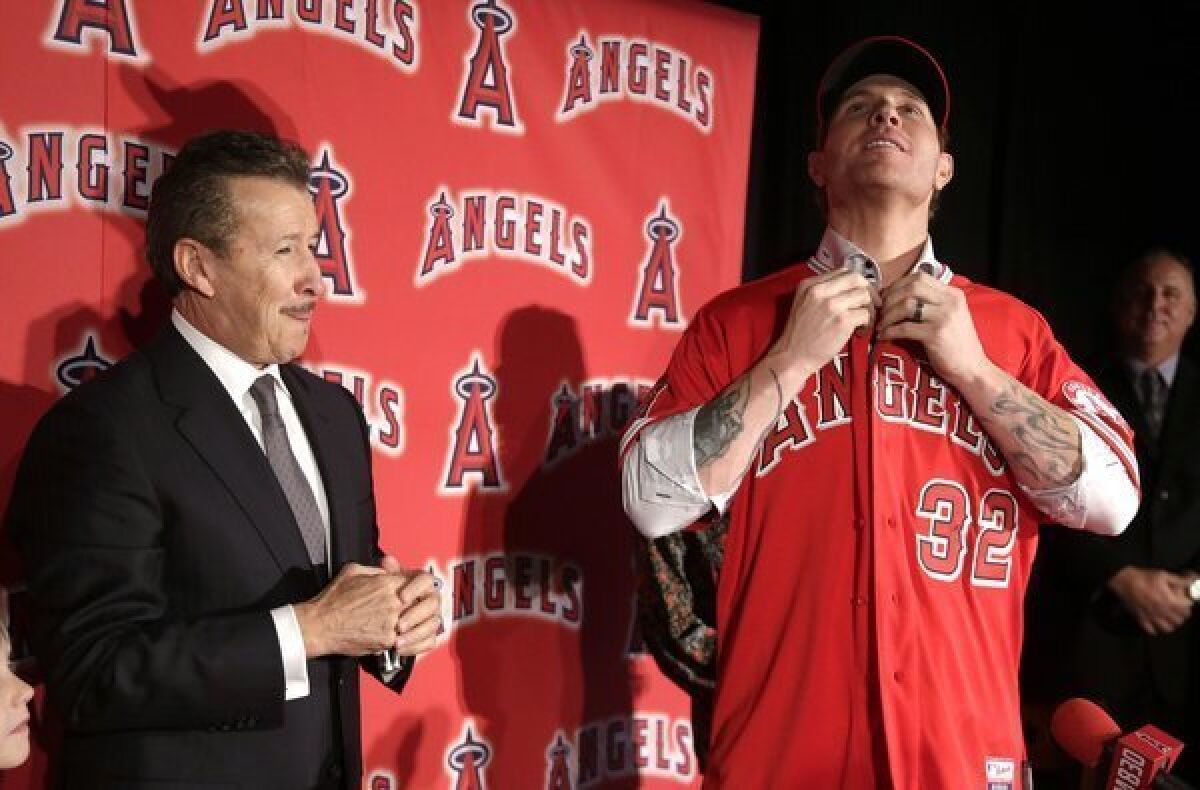 New Angels outfielder Josh Hamilton, shown with owner Arte Moreno in December, arrived at camp some 20 to 30 pounds lighter than his usual spring weight with the Texas Rangers.