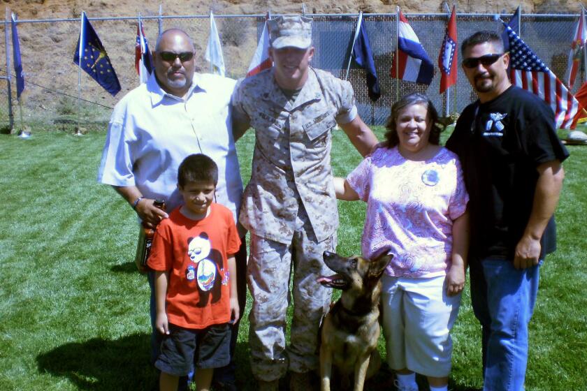 Marine dog Dino with his current handler, Sgt. Jonathan Overland, and relatives of Staff Sgt. Christopher Diaz, Dino's former handler, who was killed in Afghanistan. The Diaz family will take Dino home to El Paso.