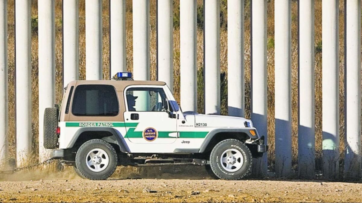A U.S. Border Patrol agent "drags" a border road next to one of the tiers of fences along the U.S.-Mexico border in San Diego December 9, 2005.