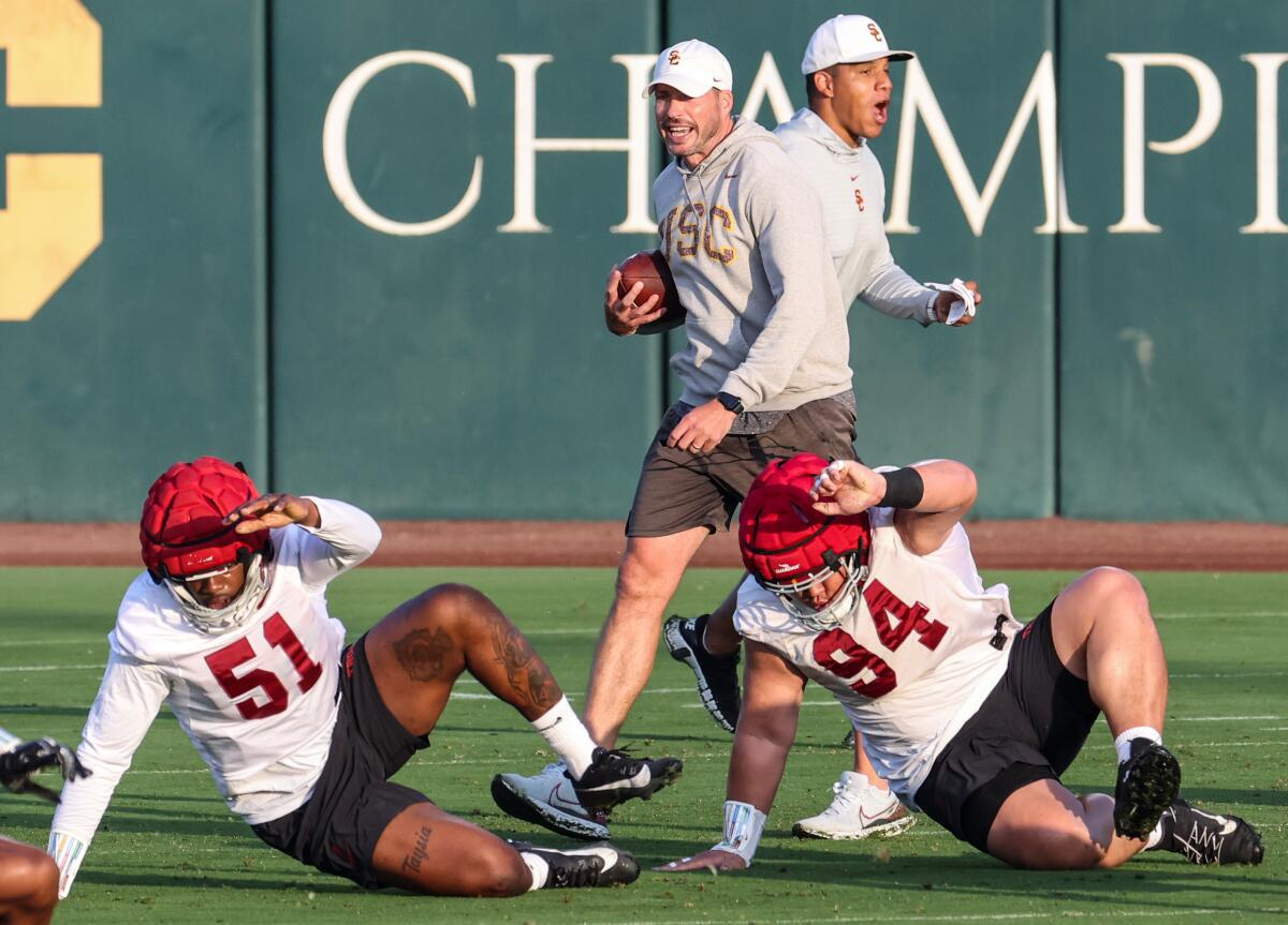 USC defensive coordinator Alex Grinch, left, and defensive passing game coordinator Donte Williams instruct player.