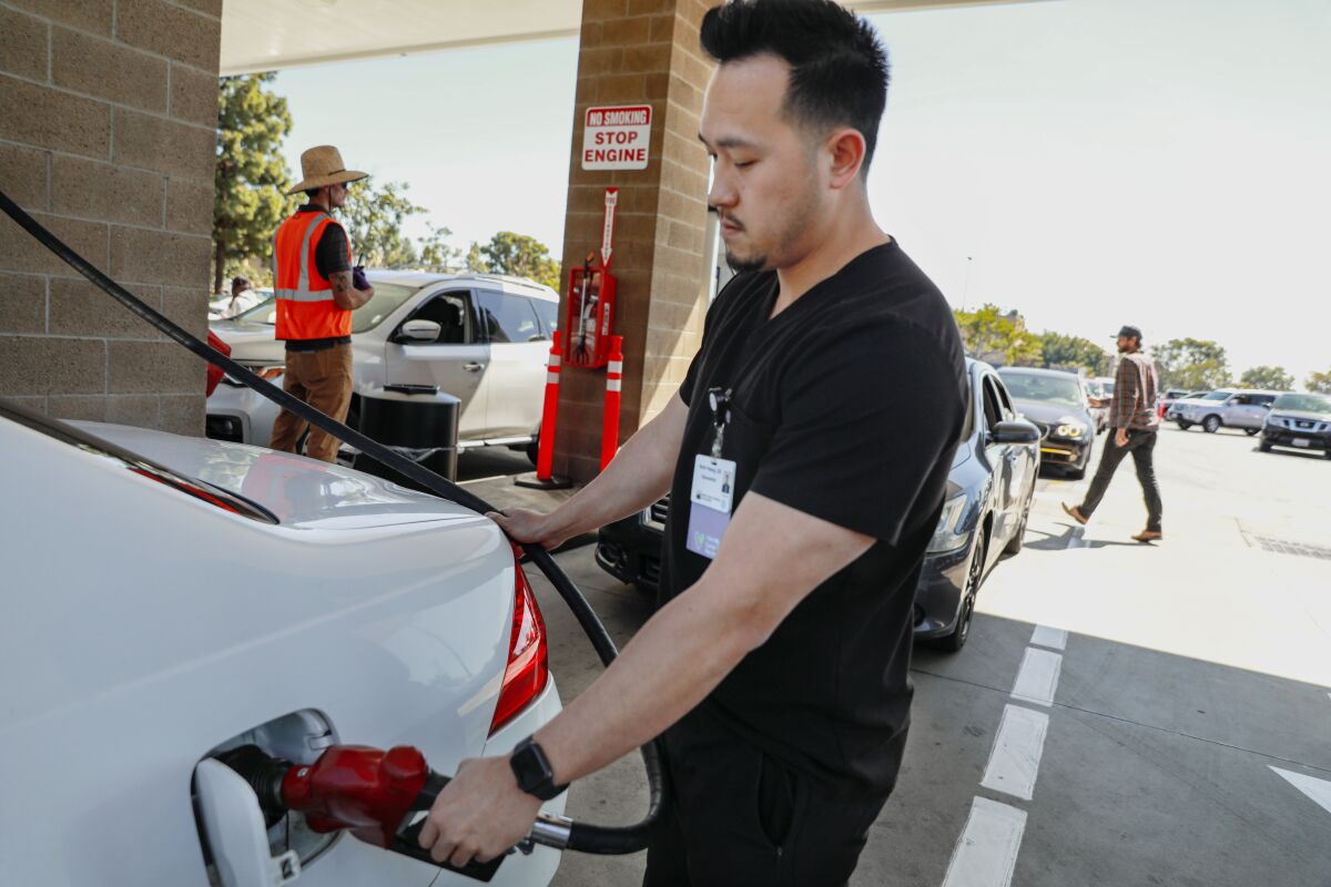 Kevin Hoang fills up his gas tank at a Costco Wholesale