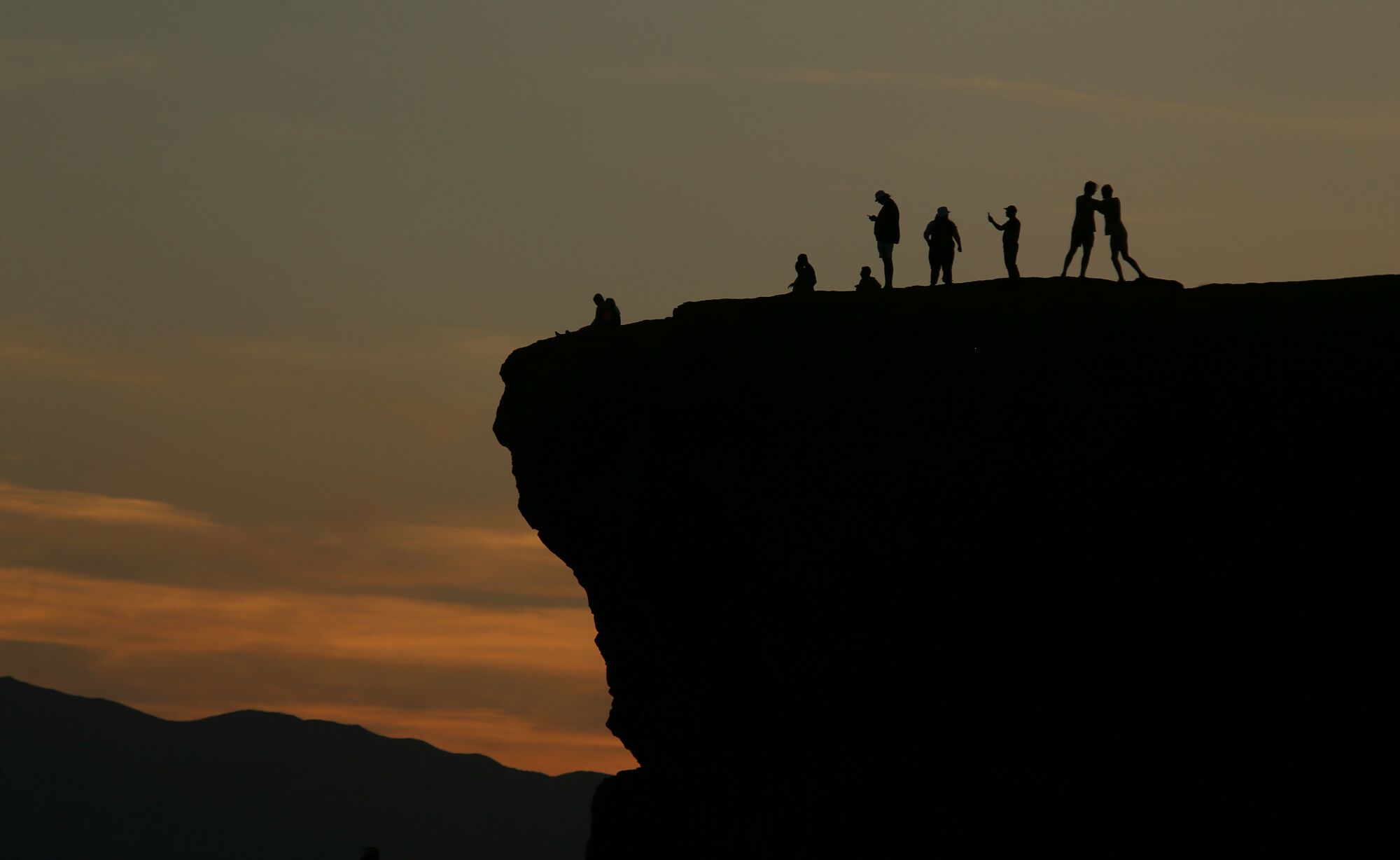 Locals watch the sunset from atop a bluff in St. George, Utah, one of the fastest-growing metropolitan areas in the nation.