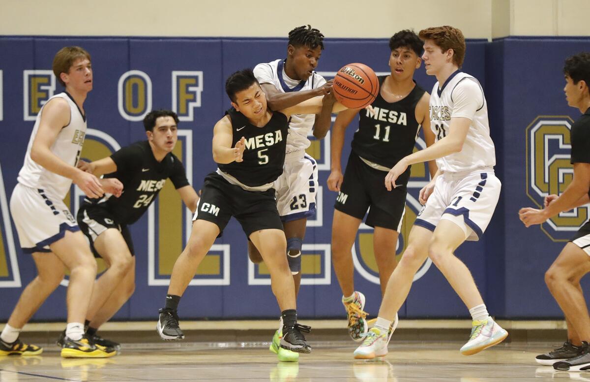 Costa Mesa's Christian Dasca (5) and Calvary Chapel's Keshawn Johnson (23) battle for a rebound.