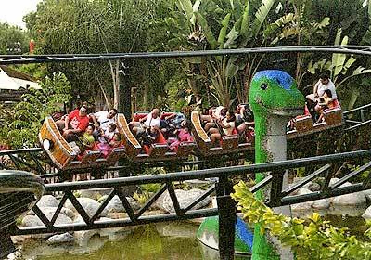 The Coastersaurus circles a dinosaur crafted from Lego bricks. The junior roller coaster is in a new dinosaur-themed area of Legoland.