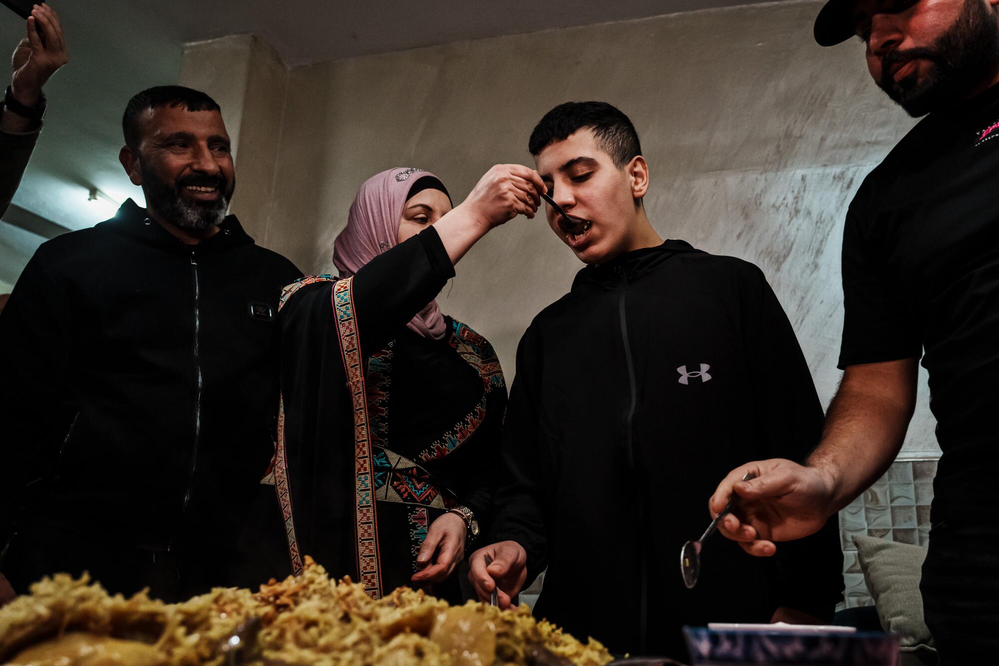  Sahar feeds her son Ahmad Salaymah, 14, home-cooked makluba after he was released from prison