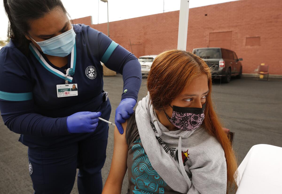 A teenager receives a shot.