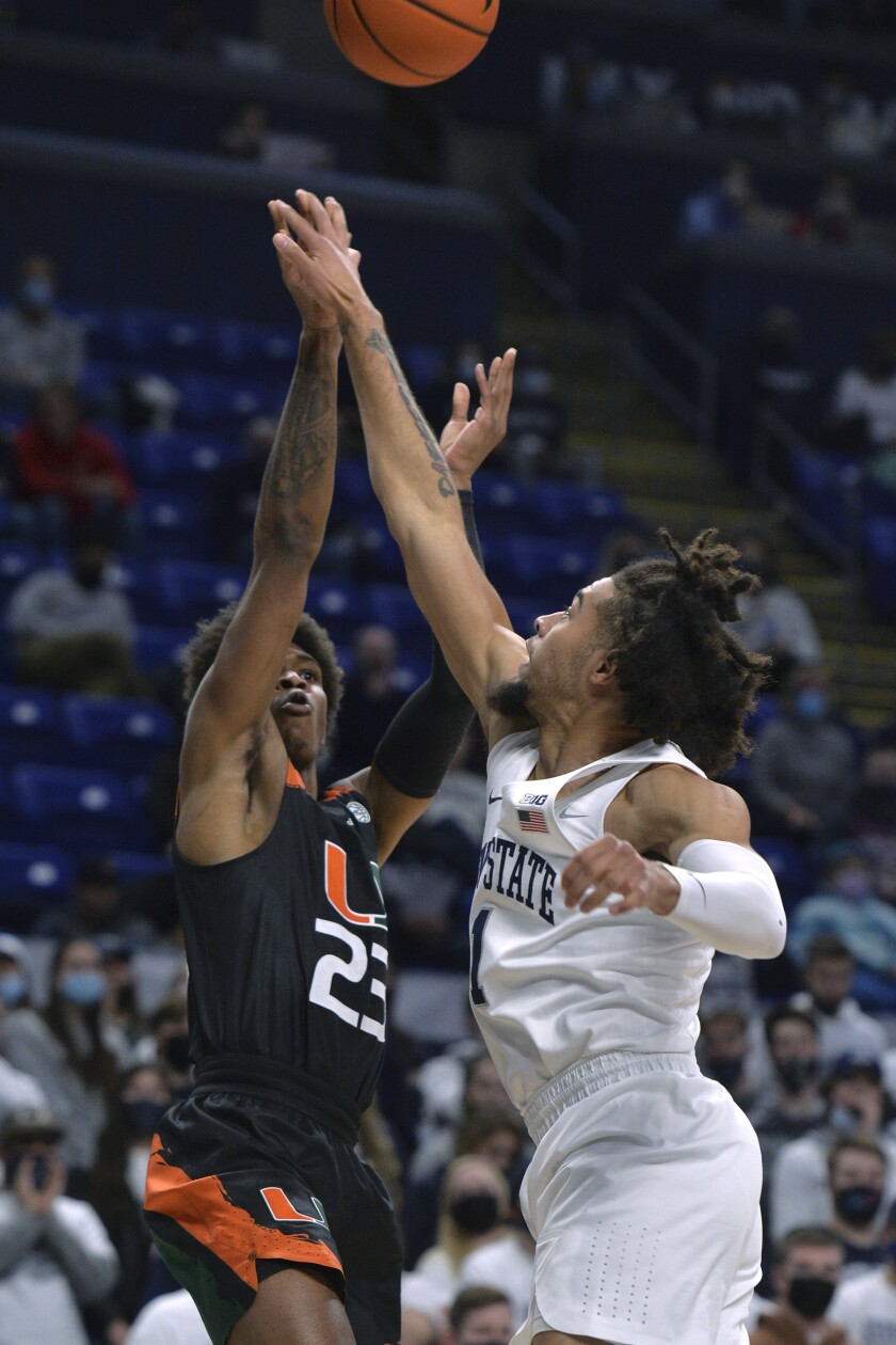 Miami's Kameron McGusty, left, shoots over Penn State's Seth Lundy during the first half of an NCAA college basketball game Wednesday, Dec. 1, 2021, in State College, Pa. (AP Photo/Gary M. Baranec)