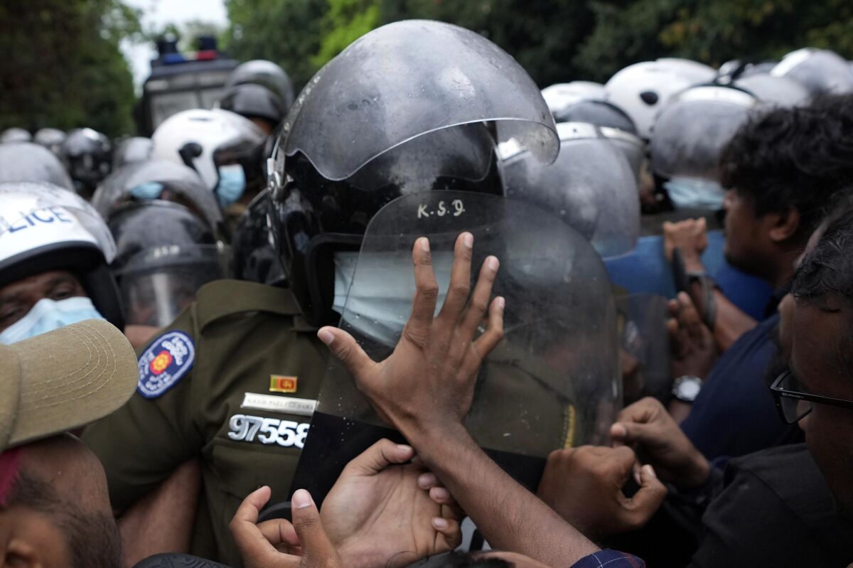 Sri Lankan undergraduates scuffle with police during a protest demanding president Gotabaya Rajapaksa's resignation near parliament in Colombo, Sri Lanka, Friday, April 8, 2022. Sri Lankan business leaders on Friday called for an end to political instability amid public demands for the president to resign over alleged economic mismanagement, warning that failure to do so would lead to economic catastrophe. (AP Photo/Eranga Jayawardena)