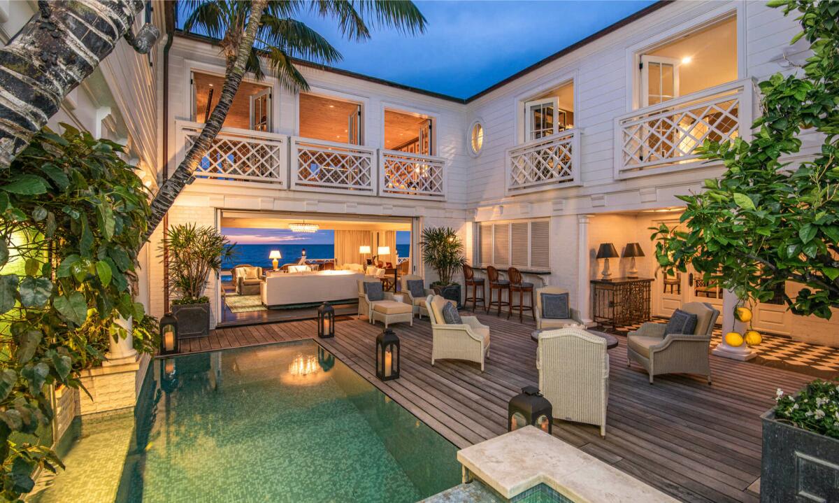The two-story home enjoys ocean views from multiple balconies and an entertainer's deck that sits above the sand.