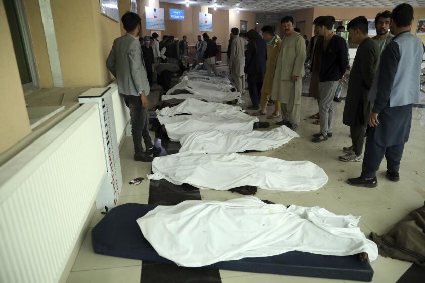 Bodies are lined up at a hospital after an explosion near a school in Kabul on Saturday.