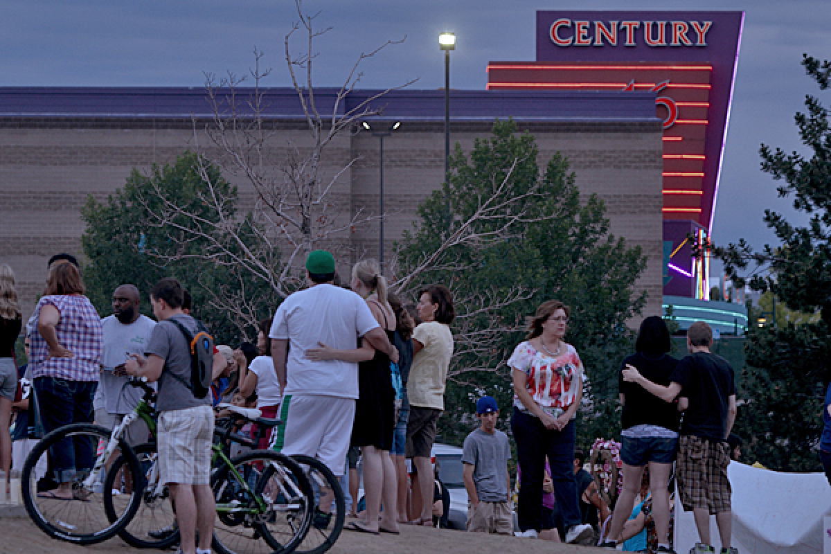 Mourners flock to the roadside memorial across the street from the Century 16 theaters in Aurora, Colorado where 12 people were shot to death and 58 wounded by a lone gunman.
