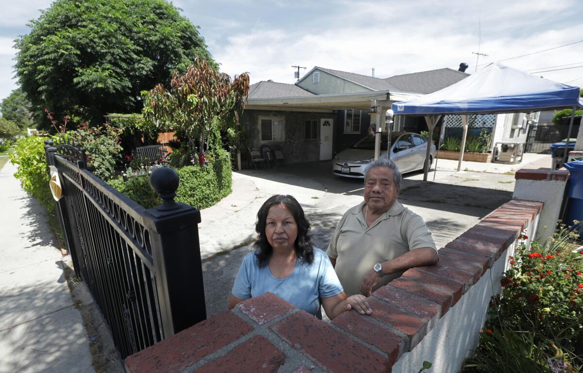 Josefina and Marcelino Rodriguez in front of the home they are afraid they will lose.