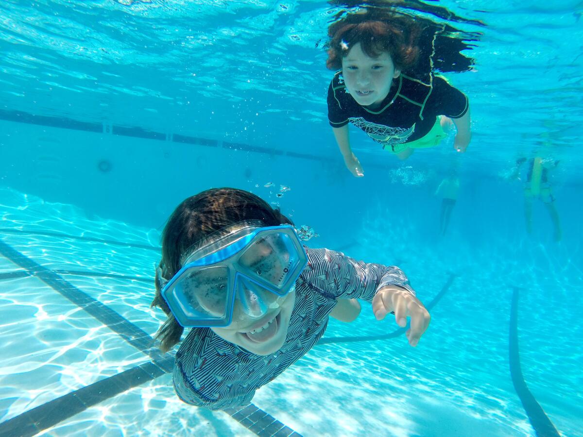 Veronica Mullen, 8 of Los Feliz, front, and her brother Montgomery, 6, keep cool by swimming under water at the La Canada Flintridge Country Club swimming pool on Wednesday, July 23, 2014. Temperatures, in the mid 90s on Wednesday, were expected to continue rising through the week.