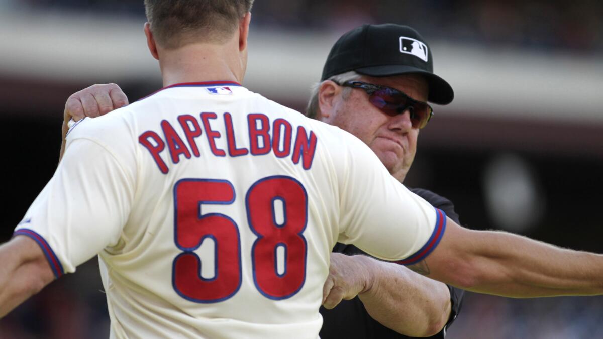 Umpire Joe West grabs the jersey of Philadelphia Phillies pitcher Jonathan Papelbon after ejecting the closer during a game against the Miami Marlins Sept. 14.