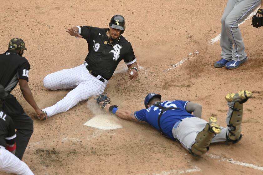 Chicago White Sox's Jose Abreu (79) slides safely into home plate while Kansas City Royals catcher Cam Gallagher attempts to apply the tag during the ninth inning of a baseball game Sunday, May 16, 2021, in Chicago. (AP Photo/Paul Beaty)