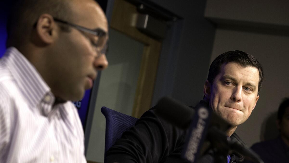 Andrew Friedman, the Dodgers' president of baseball operations, listens as General Manager Farhan Zaidi, left, talks about the departure of Don Mattingly during a news conference Thursday.