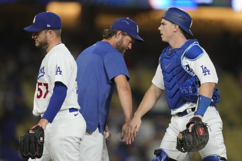 Los Angeles Dodgers' Clayton Kershaw, center, celebrates with relief pitcher Ryan Brasier (57) and catcher Will Smith.