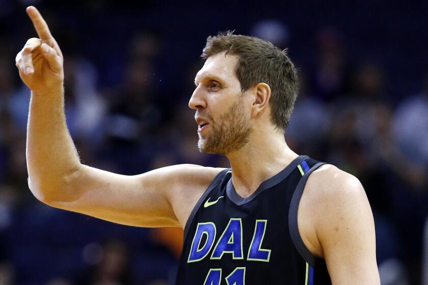 Dallas Mavericks forward Dirk Nowitzki waves to the Phoenix Suns bench prior to an NBA basketball game against the Suns, Wednesday, Jan. 31, 2018, in Phoenix. The Suns defeated the Mavericks 102-88. (AP Photo/Ross D. Franklin)