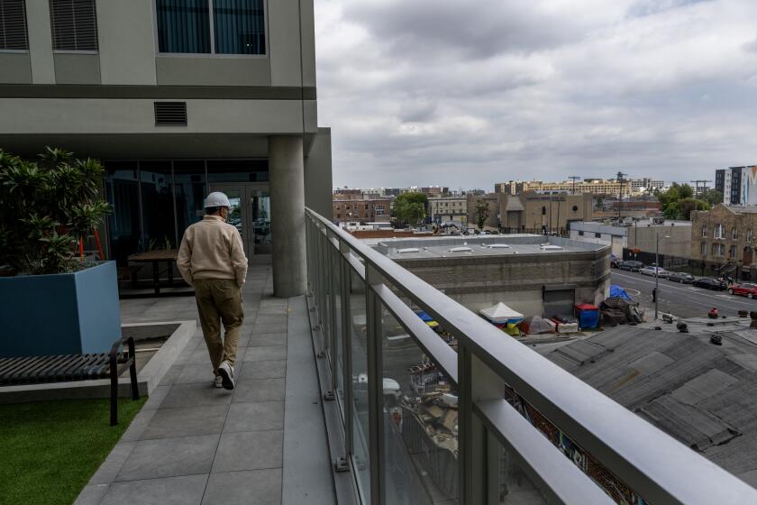 LOS ANGELES, CA - MAY 20, 2024: Kevin Murray, president and CEO of Weingart Center Association, walks in a common patio area nside Weingart's high-rise residential tower in Skid Row on May 20, 2024 in Los Angeles, California. Weingart hopes to place homeless people inside the 19-story, 278-unit modern building in the downtrodden community. (Gina Ferazzi / Los Angeles Times)