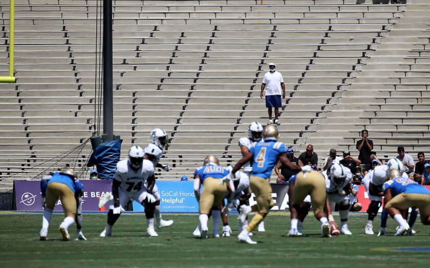 Fans watch UCLA play against Hawaii from the nearly empty north bleachers of the Rose Bowl.