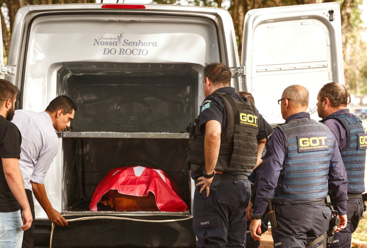 The coffin of Marcelo Arruda, a local official from the leftist Workers' Party, arrives to the Jardim Sao Paulo cemetery in Foz do Iguacu, Parana state, Brazil, Monday, July 11, 2022. Federal prison guard Jorge Jose da Rocha killed Arruda in the Brazilian state of Parana, according to state police. (AP Photo/Alexander Moschkowich)