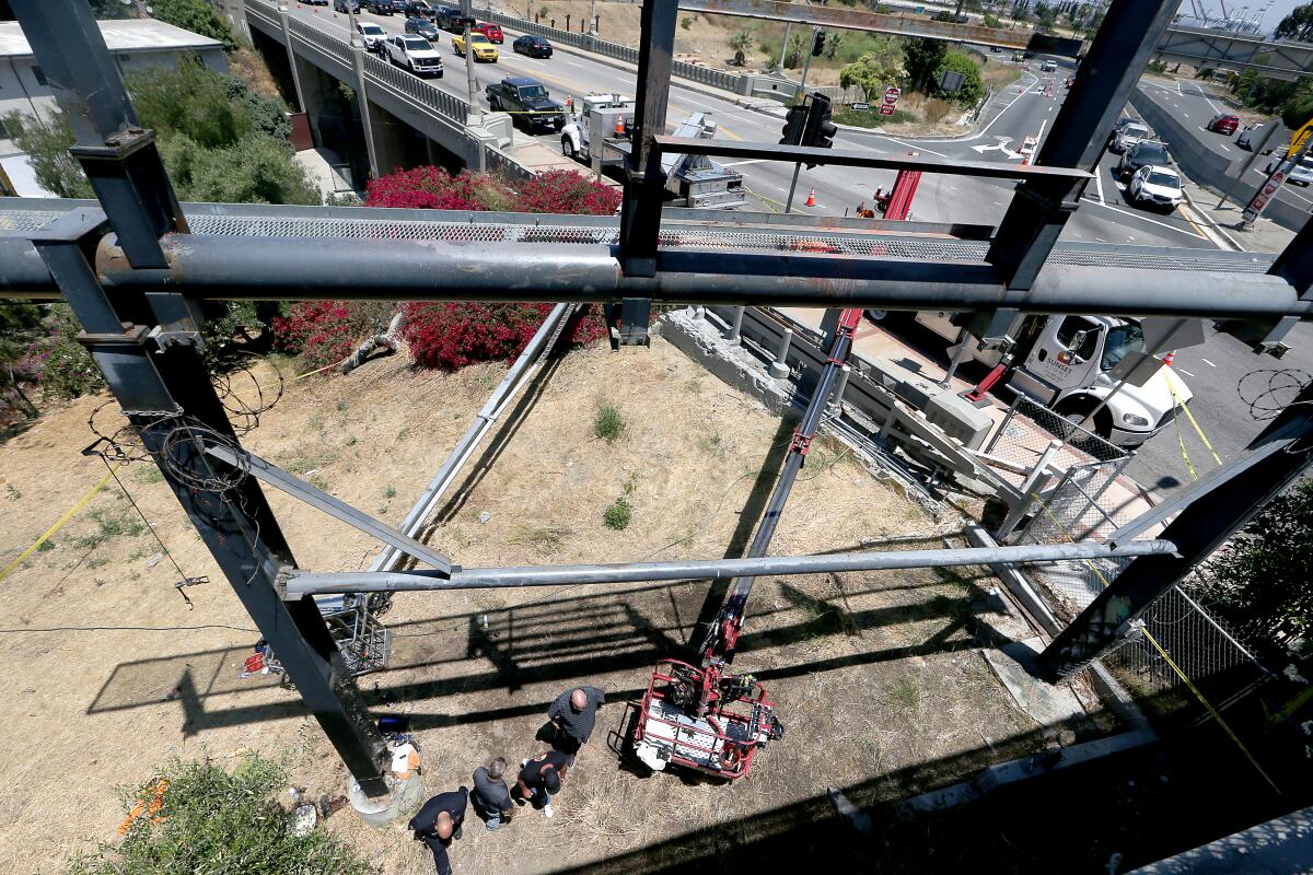 A photo taken up high on a metal structure shows people on the ground.