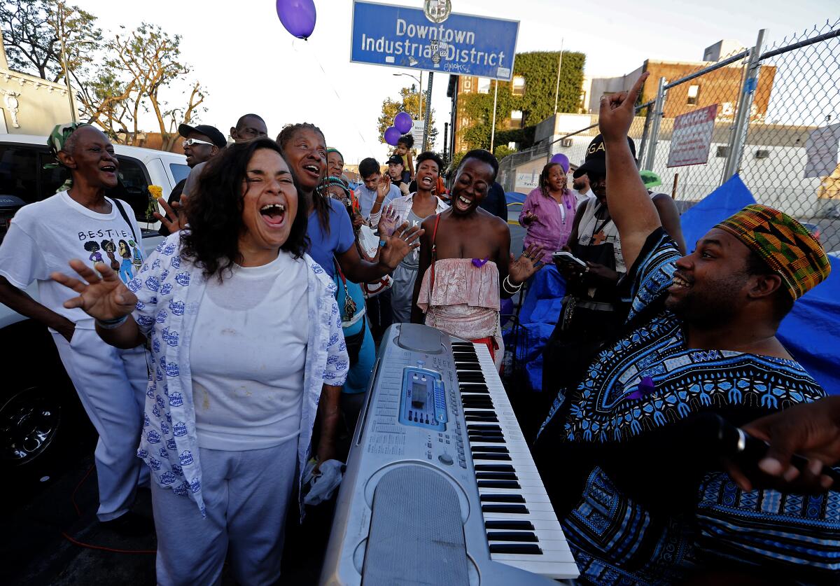 Friends of Dwayne Fields gather to sing near the intersection of 6th and San Pedro streets.