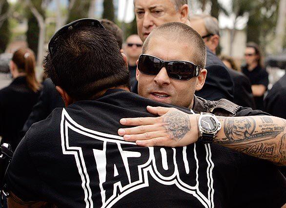Dan Caldwell gets a hug outside the Crystal Cathedral in Garden Grove, where a memorial service was held for Charles David "Mask" Lewis Jr. Lewis, who was killed in his Ferrari in a crash in March, and Caldwell co-founded the TapouT apparel company.
