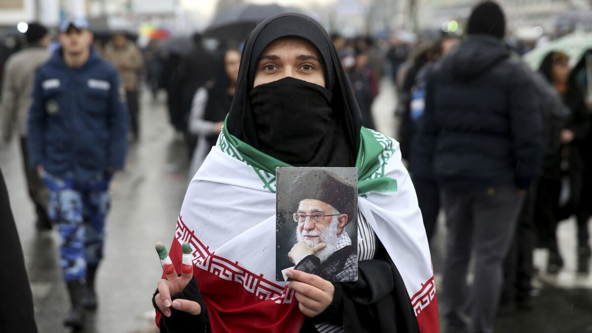 An Iranian woman holds up a portrait of Iranian Supreme Leader Ayatollah Ali Khamenei, as she makes the victory sign during a rally marking the 40th anniversary of the 1979 Islamic Revolution in Tehran on Feb. 11.