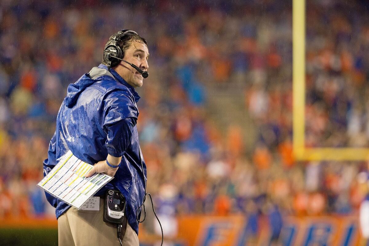 Florida Coach Will Muschamp stands in the rain before the start of the Gators-Idaho game Saturday. The game was suspended because of weather and unsafe conditions and has been rescheduled for 2017.