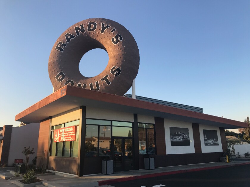 A Randy's Donuts in Downey features a large round pastry sign.