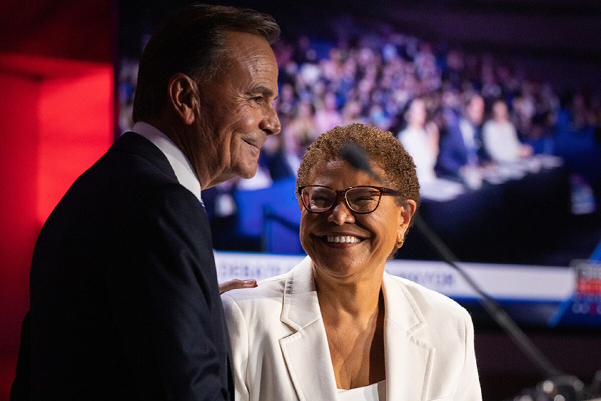 L.A. mayoral candidates Rick Caruso, left, and Karen Bass after a Sept. 21 debate
