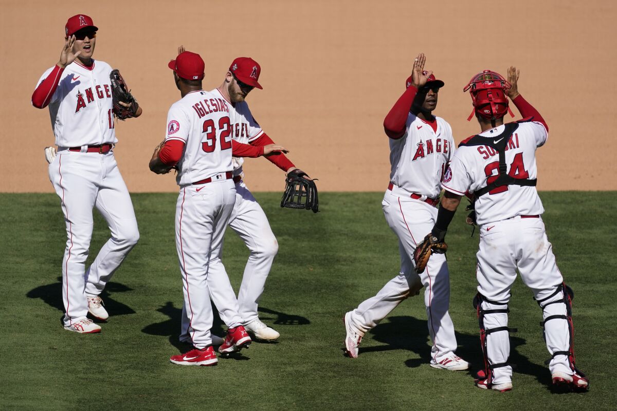 The Angels celebrate their 6-5 win over the Oakland Athletics on Sunday.