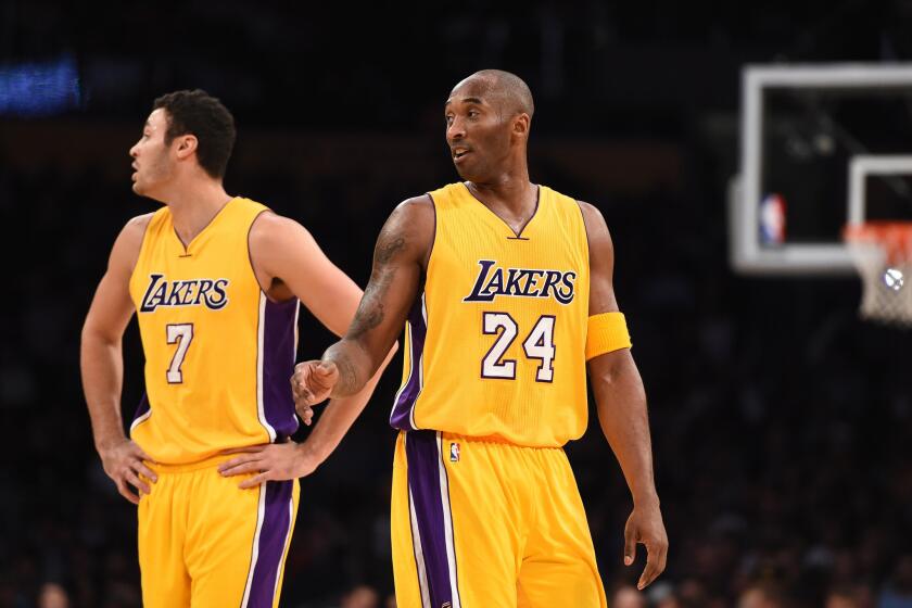 Lakers guard Kobe Bryant (24) and forward Larry Nance Jr. (7) listen to some instructions from the bench during a break against the Raptors in November.