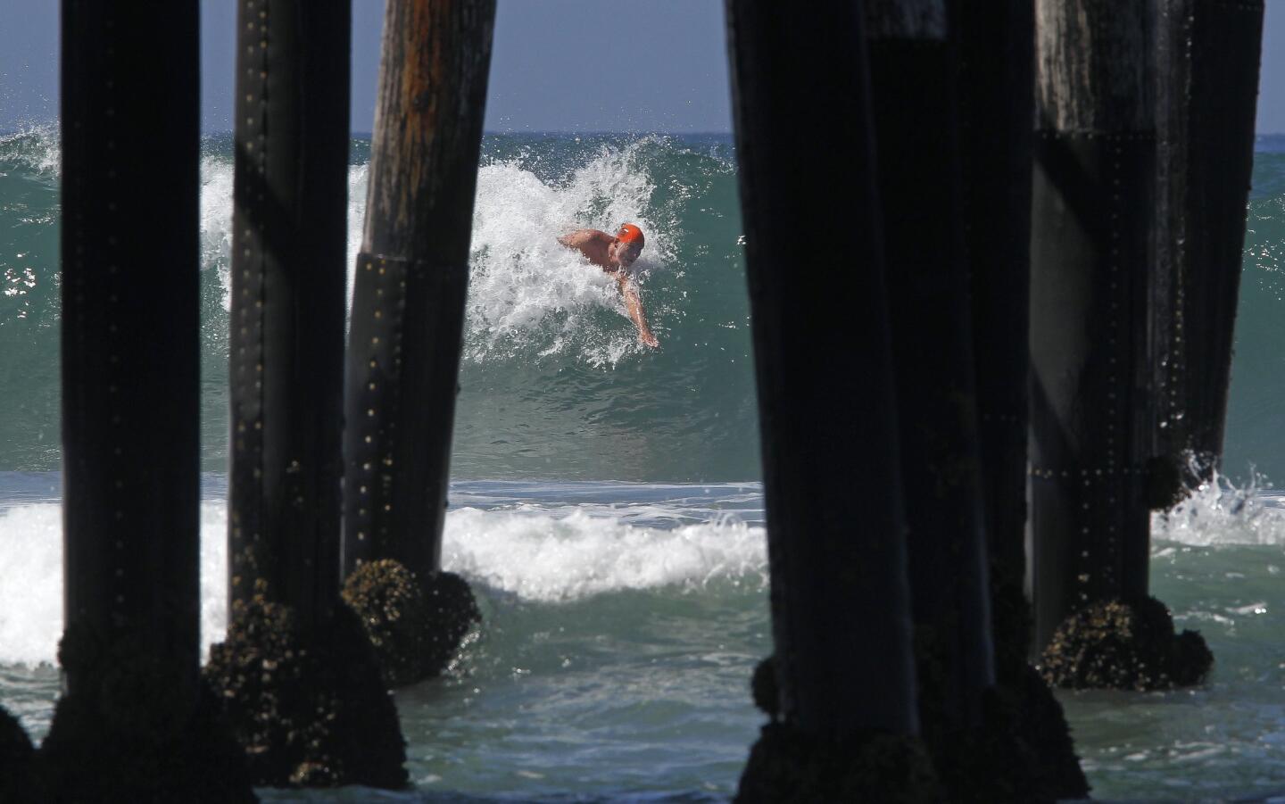A contestant rides a wave next to the Oceanside Pier during the 38th annual World Bodysurfing Championships held in Oceanside on Saturday, August 16, 2014.