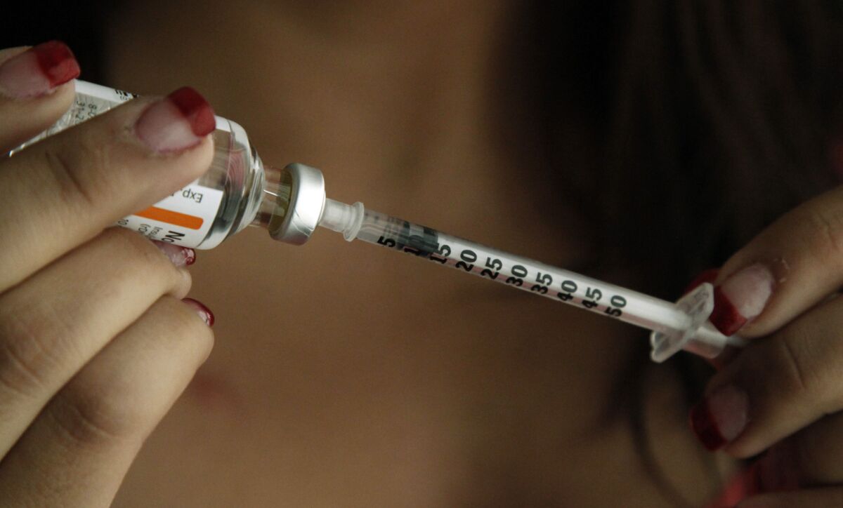 A patient fills a syringe.
