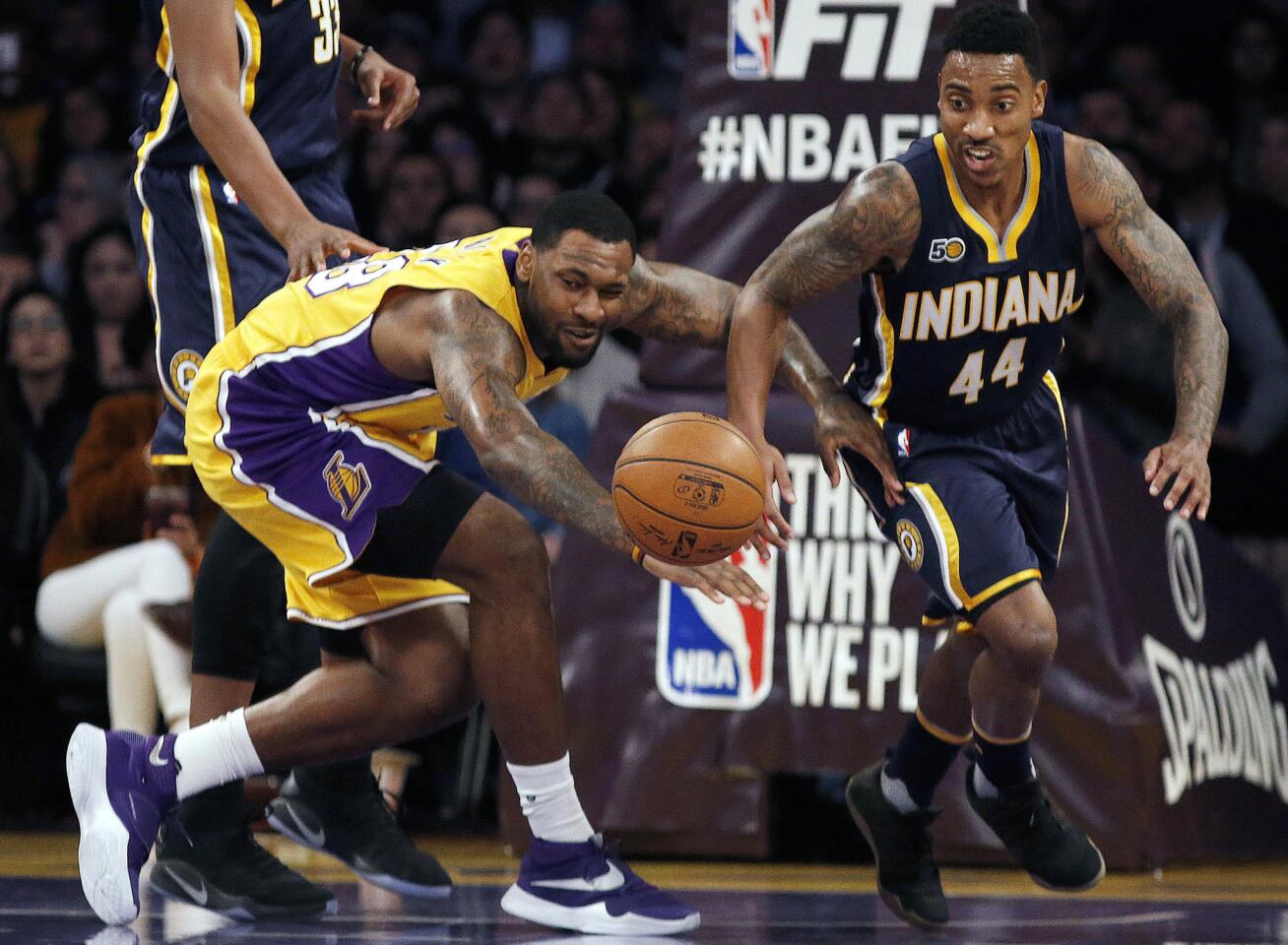 Lakers center Tarik Black goes after a loose ball next to Pacers guard Jeff Teague (44) during the first half.